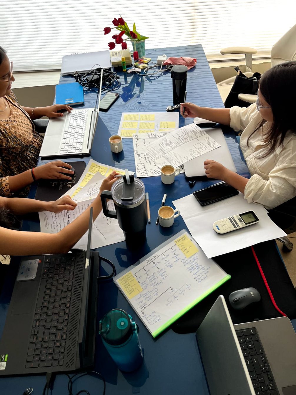 The UX Pacific team reviewing research notes around a table